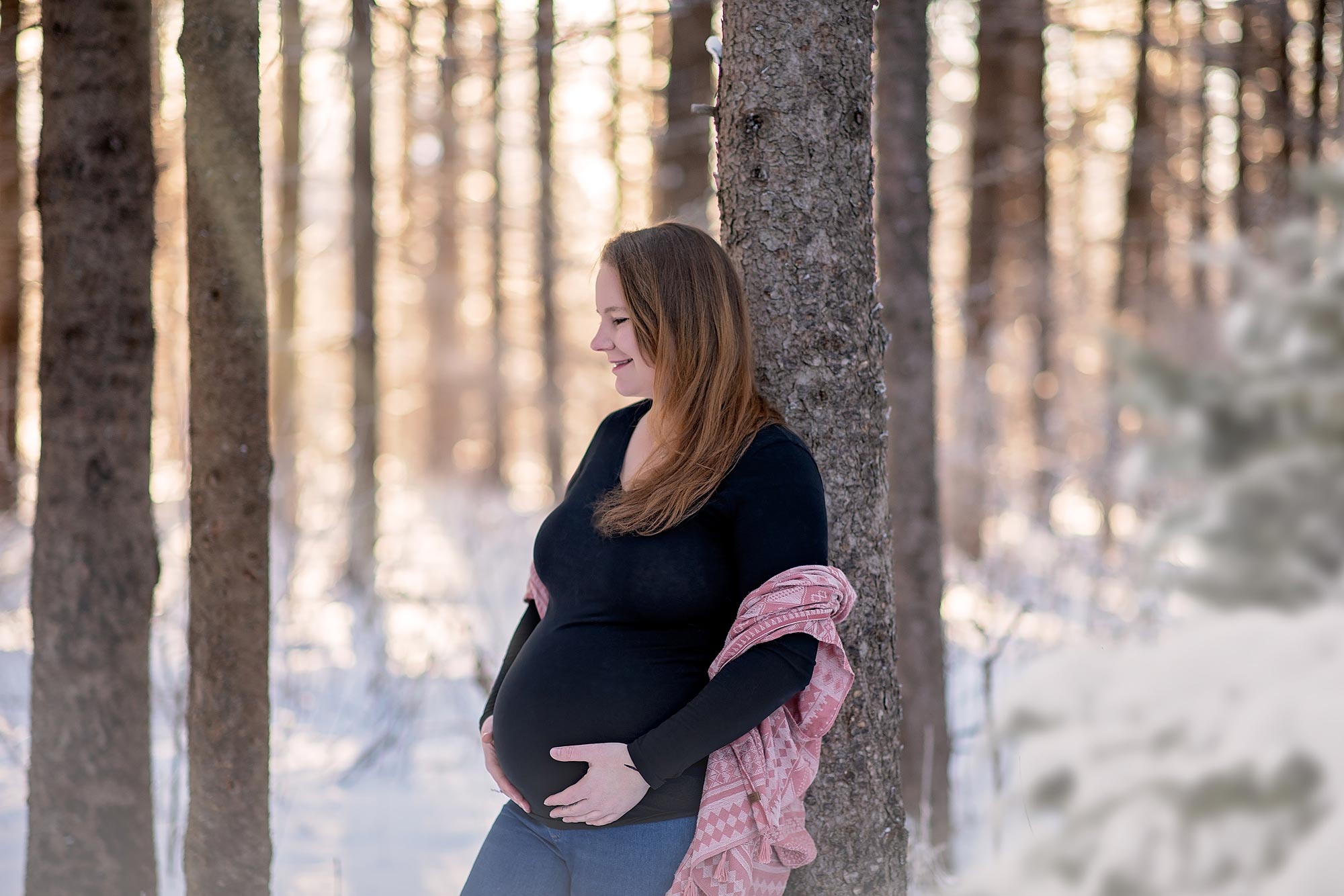 pregnant woman leaning on a tree